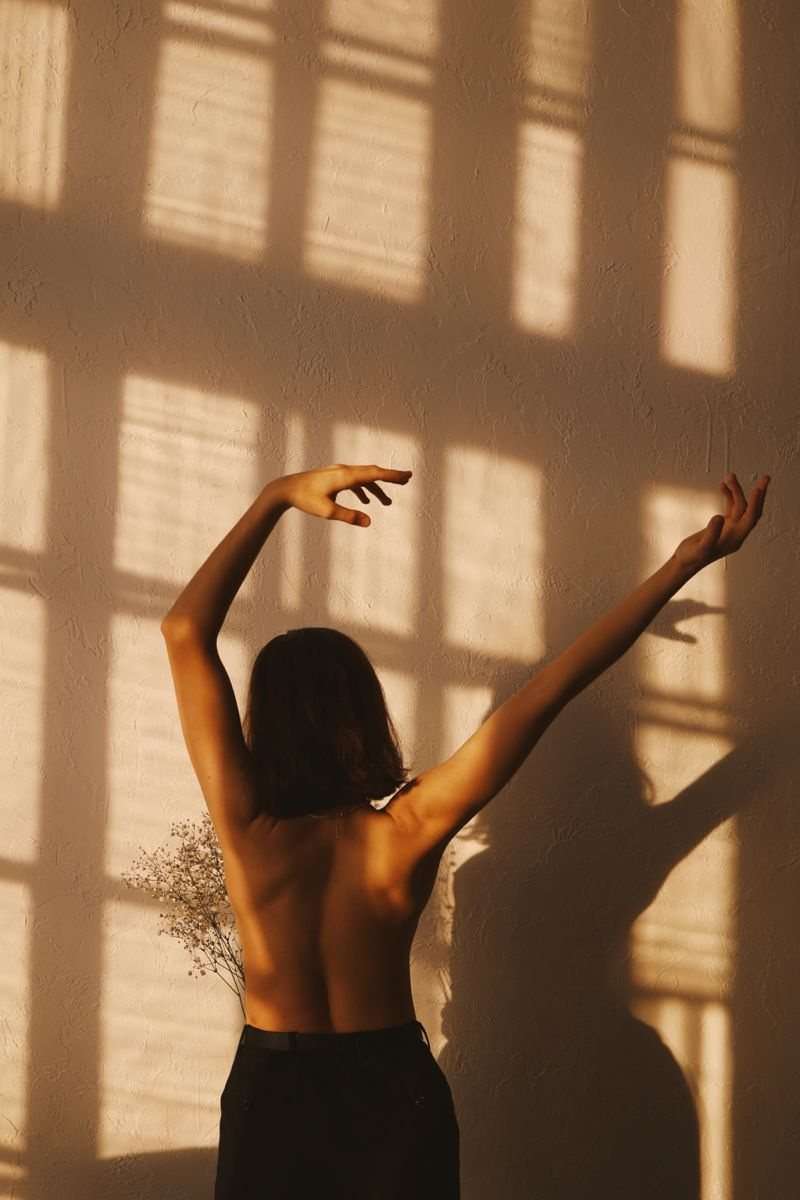 Mulher de costas com os braços erguidos